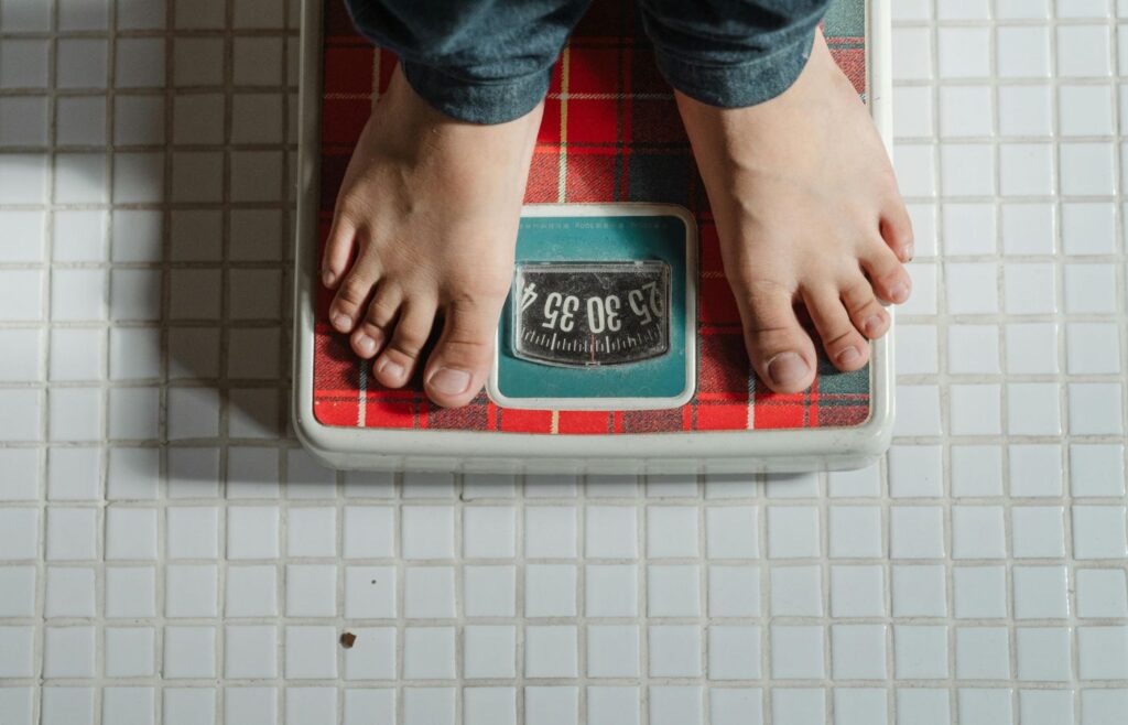 Crop kid weighing on scale