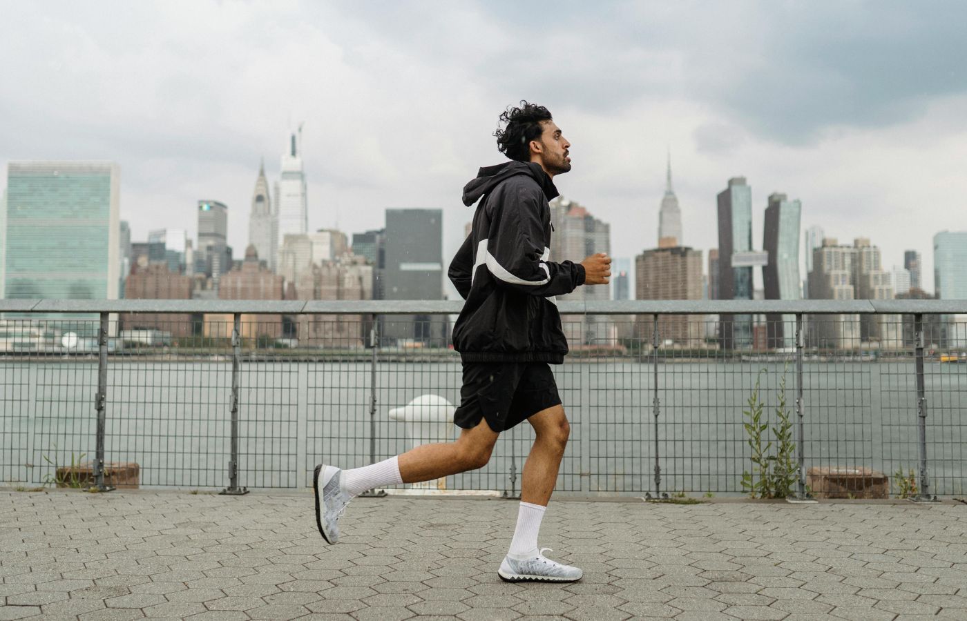 Man Wearing Jacket and Black Shorts Running in the City