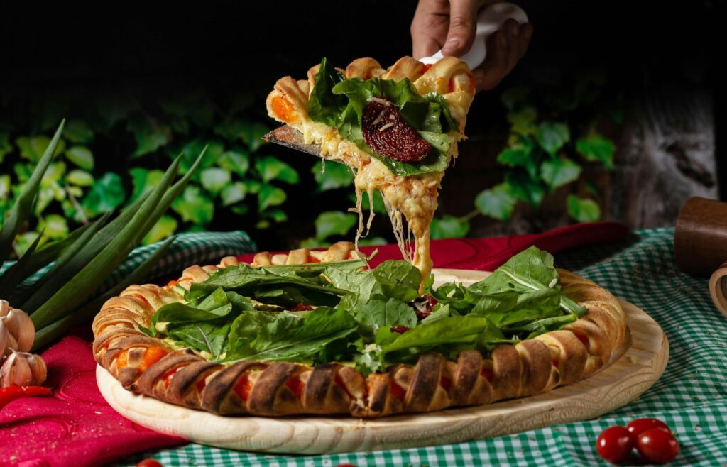Person Holding a Vegetable Pizza