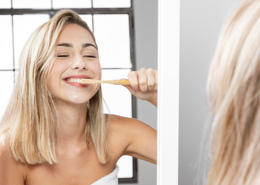 Smiling woman brushing teeth to prevent oral health and chronic disease