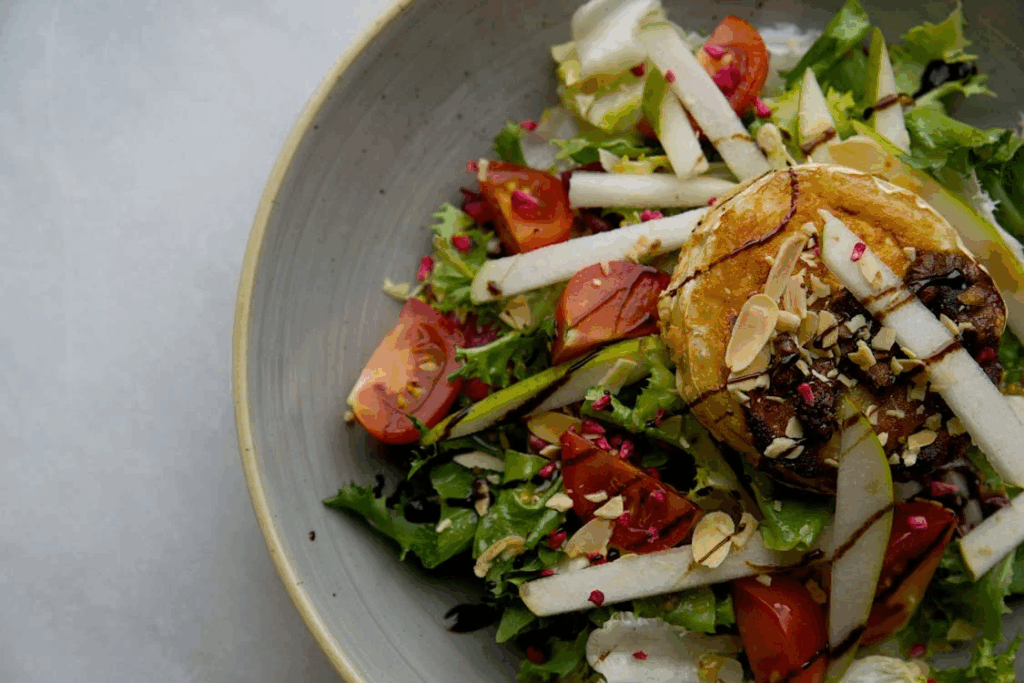 Fresh salad with leafy greens, almonds, and tomatoes as part of longevity diet foods for healthy aging.